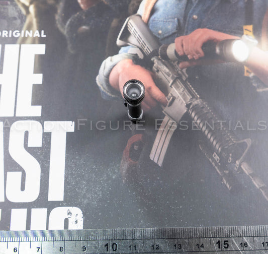 Front view of Hot Toys Joel Miller 1/6 scale torch, showing the circular lens detail and black torch head