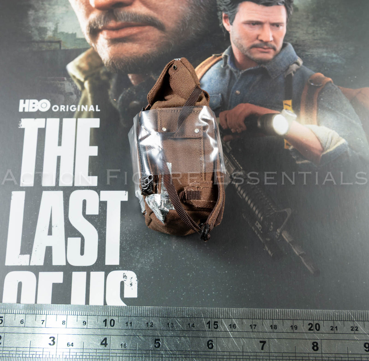 Hot Toys Joel Miller brown backpack in 1/6 scale, showing textured fabric, weathered straps and silver duct-tape repair detailing