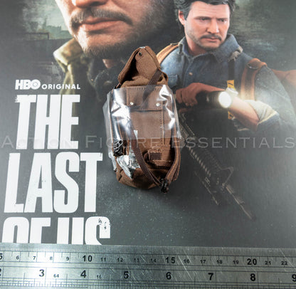 Hot Toys Joel Miller brown backpack in 1/6 scale, showing textured fabric, weathered straps and silver duct-tape repair detailing