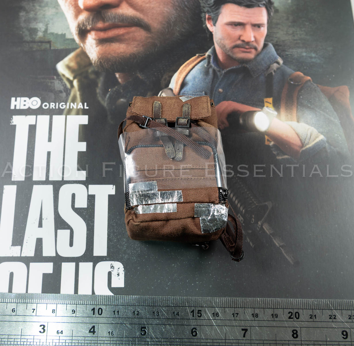 Hot Toys Joel Miller brown backpack in 1/6 scale, showing textured fabric, weathered straps and silver duct-tape repair detailing
